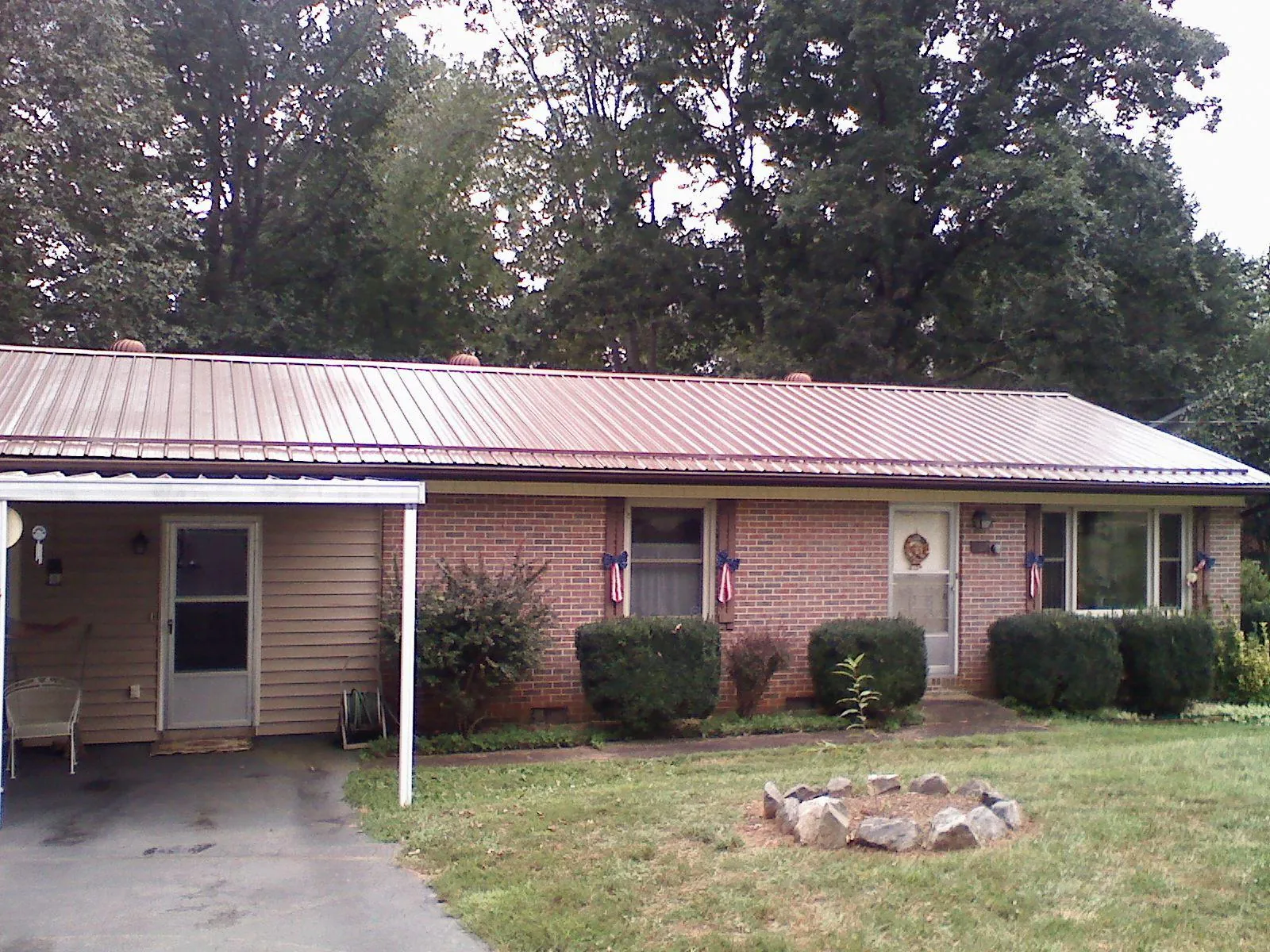 Bronze metal roof and carport on a brick ranch home — Roof Repair work by our crew in Aurora